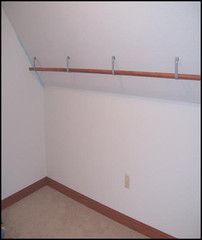 an empty room with white walls and wooden rails on the wall, along with carpeted flooring