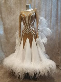 a white and gold dress with feathers on it