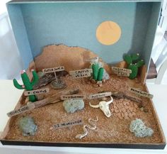 a desert scene made out of cardboard with rocks and cacti