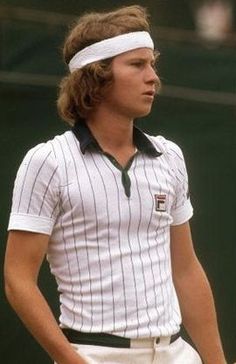 a young man holding a tennis racquet on top of a tennis court