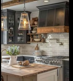 a kitchen with an island and hanging lights