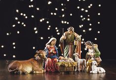 a nativity scene with figurines and lights in the background