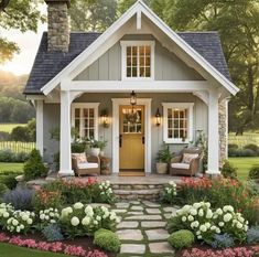 a small house with flowers in the front yard and steps leading up to the front door