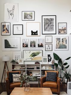 a living room filled with lots of pictures on the wall and furniture in front of it