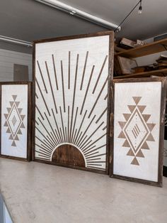 three framed art pieces sitting on top of a counter next to each other in a kitchen