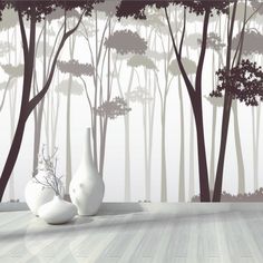 two white vases sitting on top of a wooden floor in front of a forest wall mural