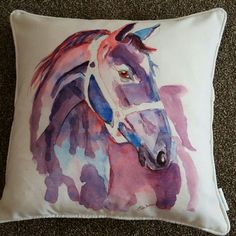 a pillow with a watercolor horse on it sitting on the floor next to carpet