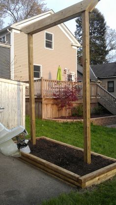 a toilet sitting in the middle of a yard next to a wooden structure and fence