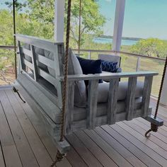 a porch swing made out of pallet wood with cushions on the back and sides