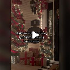 the christmas tree is decorated with red and white ribbons, bows, and presents in front of a house