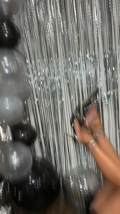 a blurry image of a person holding a cell phone in front of some balloons