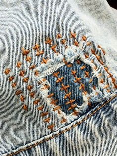 an old pair of jeans with holes in the back pocket and orange stitchs on them