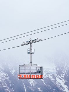 an orange and white ski lift with people on it