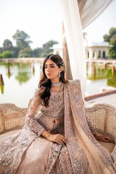 a woman sitting on top of a couch next to a white canopy covered in curtains