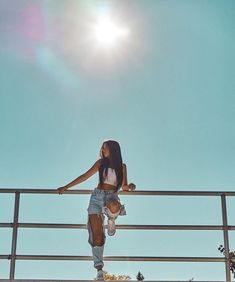 a woman standing on top of a metal rail next to a skateboarder in the sun