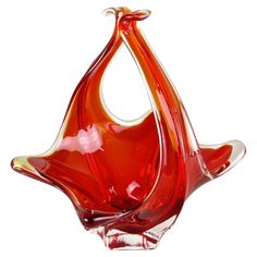 a red glass vase sitting on top of a table