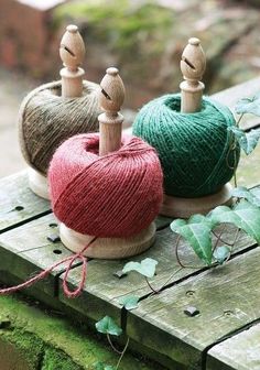 three balls of yarn sitting on top of a wooden table