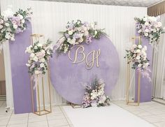 purple and white wedding decor with monogrammed initials on the wall, flowers in vases