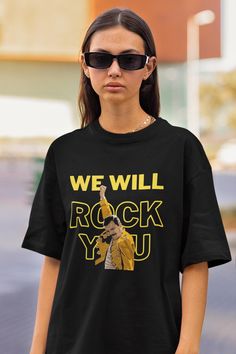 a woman wearing a black t - shirt that says we will rock you