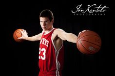 a young man holding a basketball in his right hand and wearing a red jersey with the number 33 on it