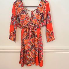 Nwt, Dress Perfect For A Concert Or Fun Night Out. Ties In The Back And Has A Deep V. Orange Sundress With Tie Back, Orange Tie-back Sundress, Orange Summer Dress With Tie Back, Spring Orange Tie Back Dress, Spring Orange Tie-back Dress, Orange V-neck Mini Dress For Vacation, Orange Tie Back Dress For Brunch, Flowy Orange Mini Dress For Beach, Vibrant Orange V-neck Dress