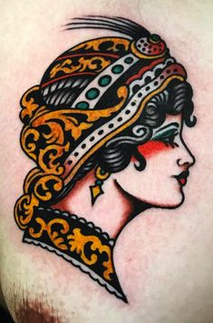 a woman's head with an ornate design on her chest and shoulder, done by tattoo artist person