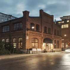 an old brick building is lit up at night with street lights shining on the windows