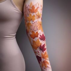 a woman's arm with leaves painted on it and the colors of autumn are shown