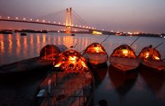 several small boats in the water with lights on them