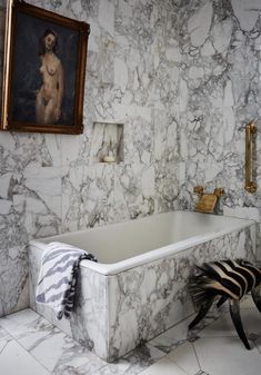 a bathroom with marble walls and flooring next to a zebra print rug on the floor