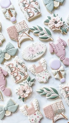 some decorated cookies are laying on a white counter top with pink and blue decorations around them