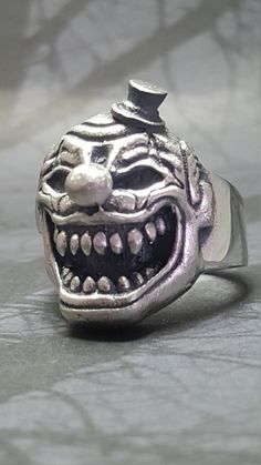 "*MAY SLIGHTLY DIFFER FROM PICTURES AS EACH ONE IS HANDMADE* .925 Solid Sterling Silver Handmade Clown Ring AMERICAN MADE Each ring is handmade and can be made any size The Weight will vary depending on size (A Size 11 Weighs 22 Grams) We have sold many rings around the world and each is custom made through a Lost Wax casting process using a hand cut master pattern Each ring is hand crafted and is stamped on the inside \"STER\" This ring will come with a black ring box and will be wrapped in an Silver Skull Ring For Halloween Streetwear, Clown Rings, Clown Ring, Unique Silver Skull Ring Hallmarked, Vintage Hallmarked Silver Skull Ring, Black Ring Box, Nickel-free Silver Gothic Skull Ring, Sugar Skull Ring, Many Rings