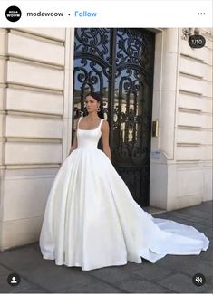 a woman standing in front of a door wearing a wedding dress