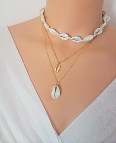 "Cowrie shell necklace, Choker necklace, Surfer necklace, Hawaiian necklace, Surfer Girl necklace, Friendship necklace, Cowrie necklace ★Details: This listing is for your choice of a single necklace. ✦ Cowrie Gold Pendant Necklace / Beaded Chain/ 16\" ✦ Real Cowrie Pendant Necklace / Plain Chain/ 18\" ✦ Real Cowrie Choker: The necklace is secured by tying knot at the back of the neck. This choker necklace is fully adjustable with total length up to 35 inches. The shell portion of the necklace is White Shell Charm Necklace Gift, Shell Clavicle Chain Jewelry, White Adjustable Clavicle Chain Layered Necklace, Adjustable White Layered Clavicle Chain Necklace, Shell Clavicle Chain Jewelry For Beach, Beach Shell Clavicle Chain Jewelry, Shell Necklace With Clavicle Chain For Beach, White Shell Charm Necklaces, Shell Clavicle Chain Necklace For Beach