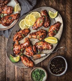 grilled chicken wings with lemon wedges and garnishes