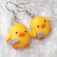 two yellow rubber ducks with orange beaks on white furnishing and silver earwires