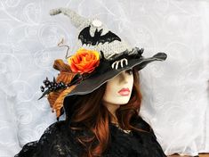 "The Bat and Bone Witch Hat has a touch of dark elegance, with a lace bat flying from the dark foliage with the full moon above. The black gauze hat band has a skeleton hand and long bones, with one dangling off the side. An orange rose blooms from the leaves and twigs. Soft but still firm enough to hang on a hook or rest on your table. Tuck in folds or wear the point up straight. Crocheted and felted, this hat is naturally water resistant. The crochet body allows for a soft stretchable fit that Bone Witch, Button Moon, Witches Night, Witches Night Out, Dark Foliage, Crochet Bodies, Night Witches, Bat Flying, Dark Elegance