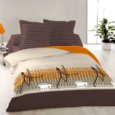 a bed with orange and brown comforters in a room next to a plant on the floor