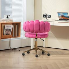 a pink office chair sitting on top of a hard wood floor next to a desk