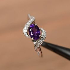 It is a natural amethyst ring. The main stone is 5mm*7mm oval cut, weight about 0.76 carats.The basic metal is sterling silver and plated with rhodium.To change the metal to a solid gold (white/rose) or platinum is also available, please ask for a quotation if you want.You can also go to my shop Home for more elegant rings: https://www.etsy.com/shop/godjewelry?ref=hdr_shop_menu More amethyst rings: https://www.etsy.com/shop/godjewelry?ref=seller-platform-mcnav&section_id=20709248Customization is Oval Purple Diamond Ring With Gemstone Accents, Oval Amethyst Ring In White Gold For Anniversary, Oval White Gold Amethyst Ring For Anniversary, Oval Amethyst Cubic Zirconia Promise Ring, Oval Purple Amethyst Ring With Gemstone Accents, Oval Amethyst Ring With Cubic Zirconia For Promise, Oval Amethyst Cubic Zirconia Ring, Oval Purple Amethyst Ring With Cubic Zirconia, Oval Amethyst Ring With Cubic Zirconia