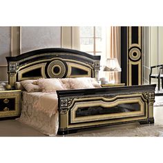 an ornate black and gold bedroom with white bedding, nightstands and mirror on the wall