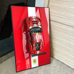 a framed photograph of a red race car