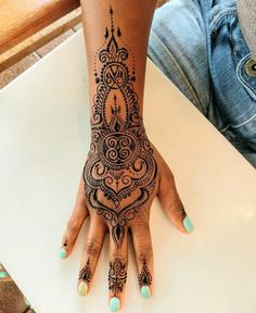 a woman's hand with henna tattoos on it