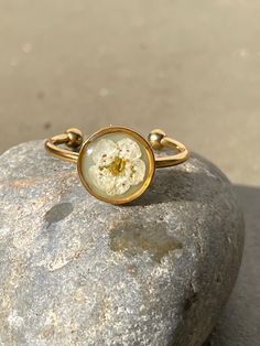 Dainty but stunning! Adjustable and stackable resin ring with white flower atop a garden green color resin background  8mm gold finish bezel Stainless steel adjustable ring Dainty Flower Ring For Spring, Gold Open Ring Flower Ring For Spring, Gold Open Flower Ring For Spring, Adjustable Gold Flower Ring Nature-inspired, Adjustable Gold Flower Ring, Nature-inspired, Nature-inspired Gold Flower Ring With Birth Flower, Nature-inspired Gold Birth Flower Ring, Adjustable Rose Gold Flower Ring, Spring Jewelry With Pressed Flowers For Gifts