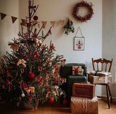 a living room with a christmas tree in the corner and presents on the floor next to it