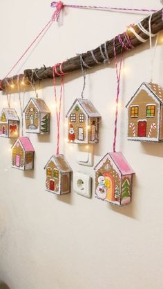 christmas decorations are hanging on the wall in front of a white wall with string lights