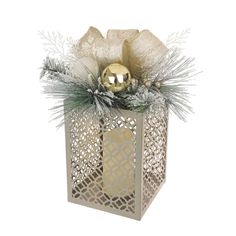 a golden ornament in a white box with pine cones and snowflakes