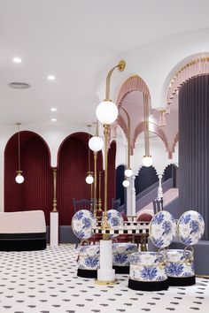 an elaborately decorated dining room with blue and white plates on the floor, chandeliers and lamps