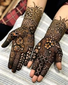 two hands with henna tattoos on them, one is showing it's intricate designs