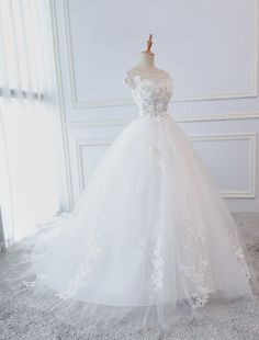 a white wedding dress on display in front of a window